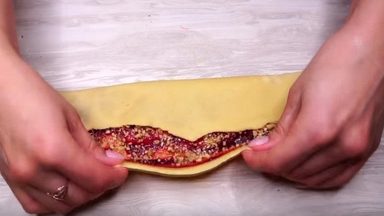 Giramos los bordes de la masa hacia el centro, formando un rollo