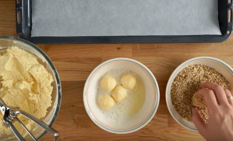 După proteine, transferăm piesele în firimituri de nuci și rulăm.