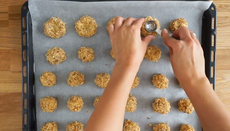 Facem o depresiune în fiecare cookie cu ajutorul unei linguri.