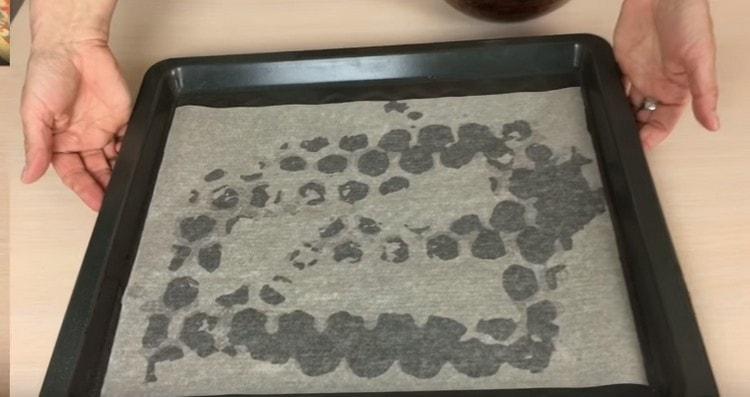 Täck den smörda bakplåten med pergament.