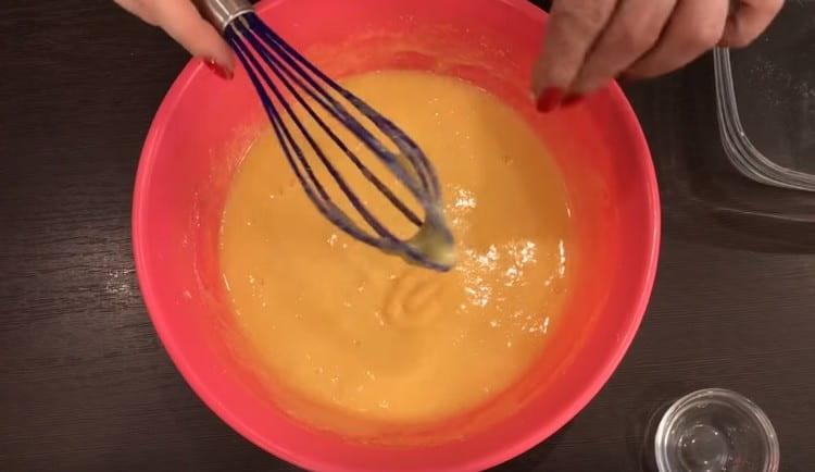 Vi introducerer sukker i dele og gnider ægmassen godt.