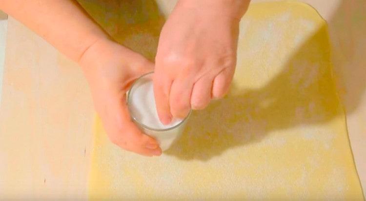 Se presara aluatul rulat cu faina.