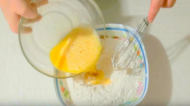 Adăugați amestecul de ouă și bere la făină.