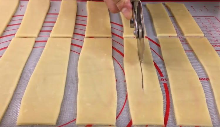 Cortamos las tiras en 3 partes cada una y hacemos cortes en el centro de los espacios en blanco.