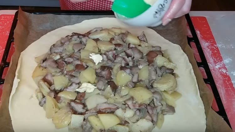 Après avoir déposé la pâte sur une plaque à pâtisserie, répartissez la garniture dessus et déposez-y plusieurs morceaux de beurre.