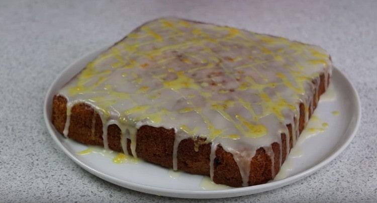 Despeje o bolo de cenoura com glacê branco e amarelo.