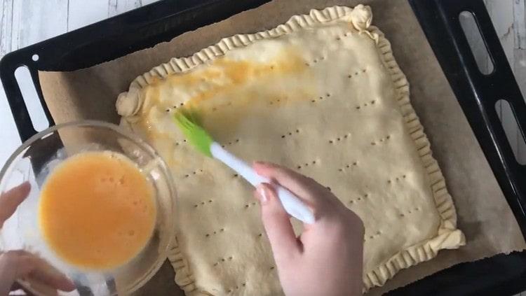 Engrasa un pastel con un huevo batido.