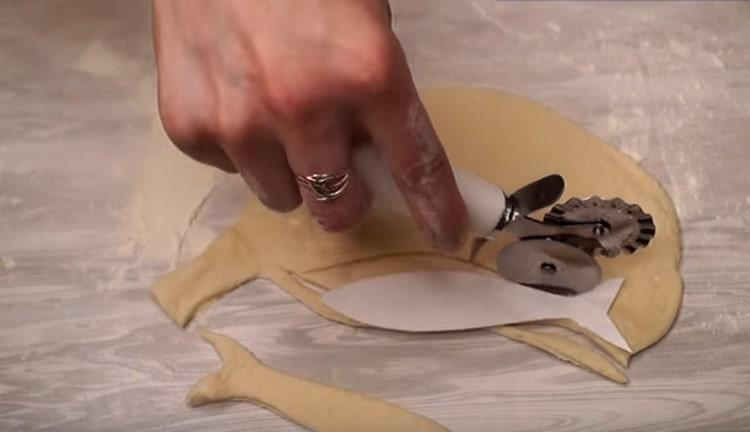 Fra resterne af dejen skærer vi fisken ud til dekoration af bageformen.