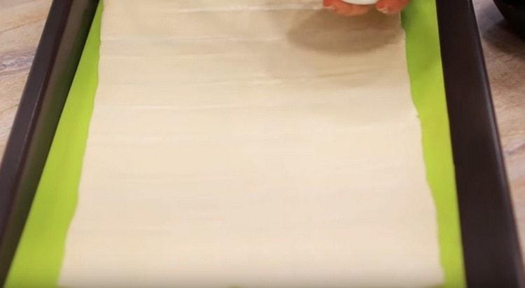 På en bakplatta lägger vi ut ett rektangulärt lager av den färdiga degen.