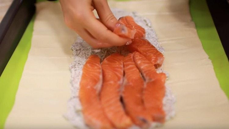 Ovanpå osten sprider vi bitarna av fisken.