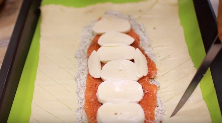 På sidorna av fyllningen gör vi sneda skär på degen.