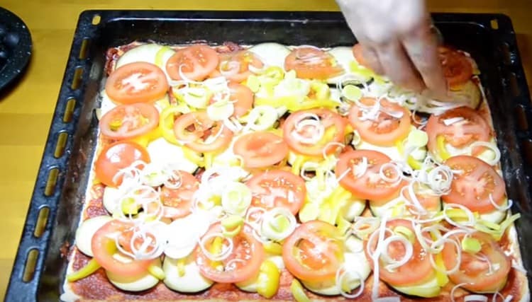 Em cima da pimenta, fazemos uma camada de tomate e polvilhamos com alho-poró.