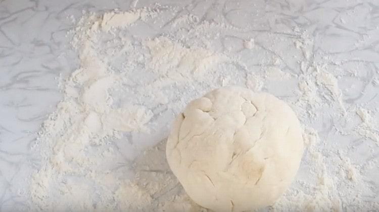 We roll the dough in flour, forming a ball.