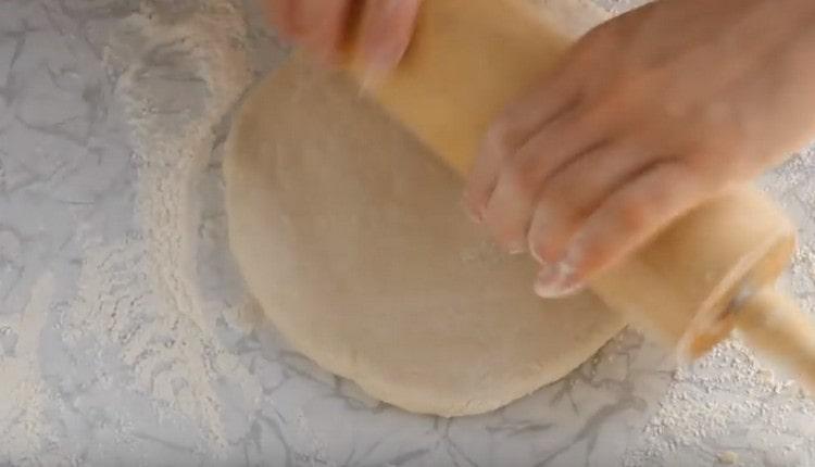 Roll out the dough into a circle with a rolling pin.