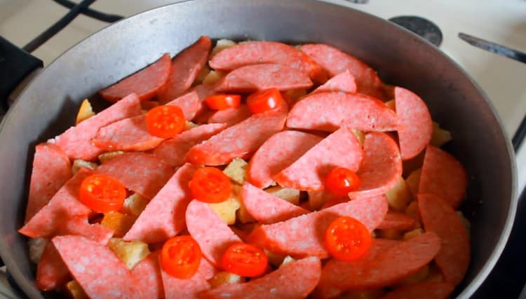 Na bochník položíme plátky klobásy a rajčat.