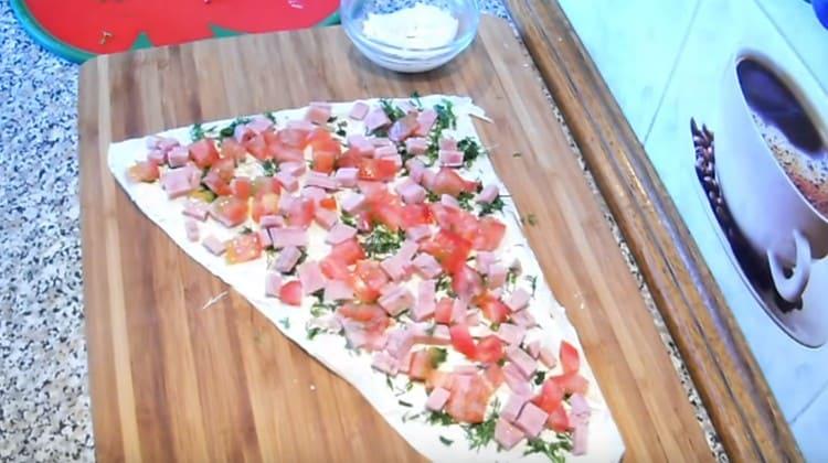 Întindeți o parte din roșii și șuncă uniform.