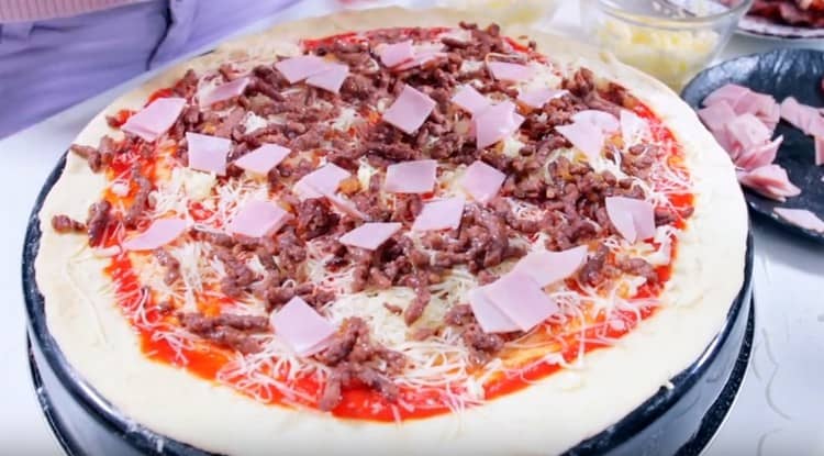 Întindeți uniform bucăți de șuncă.