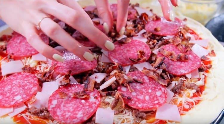 Întindem frumos cercurile de salam și le stropim totul cu slănină tocată fin, pe care am prăjit-o.