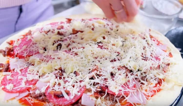 Presărați brânză deasupra pizza.