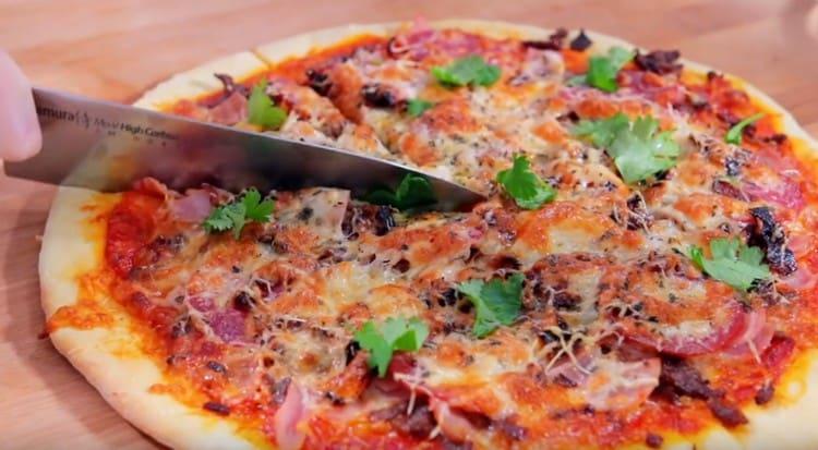 Pizza minunată de carne poate fi garnisită cu ierburi proaspete atunci când este servită.