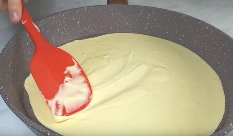 Разпределете равномерно тестото върху тигана.