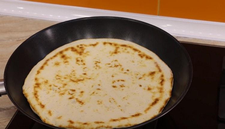 Den Kuchen wenden und die Pfanne vom Herd nehmen.