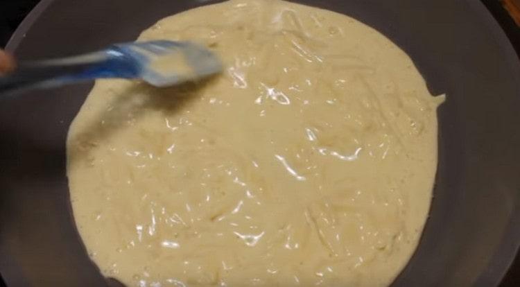 Vi spreder dejen i panden, udjævner den og dækker den med et låg.