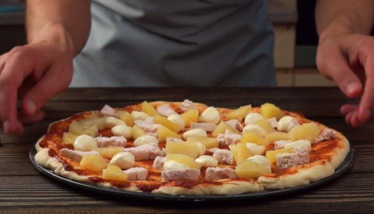 Položíme kousky kuřecího masa a ananasu na obrobek.