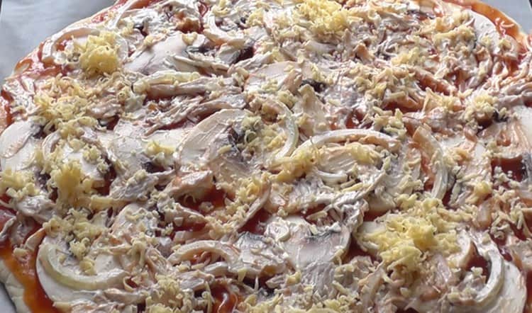 Espolvorea la pizza con queso y ponla en el horno.