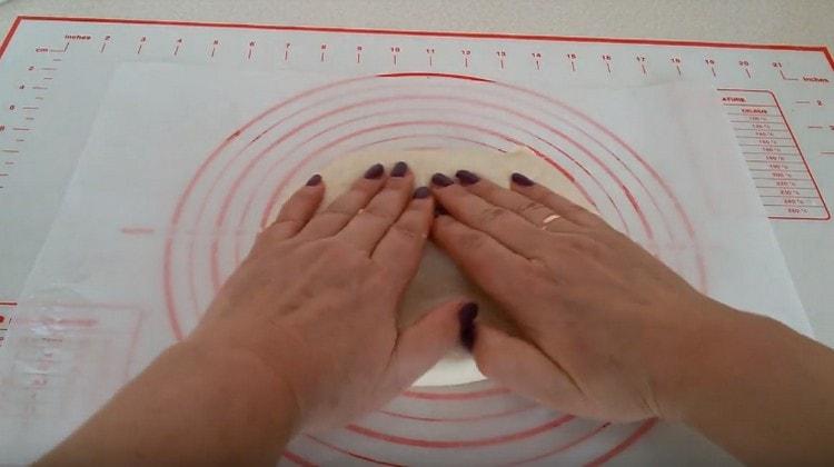 Hamuru elinizle gerin, pizzaya temel hazırlayın.