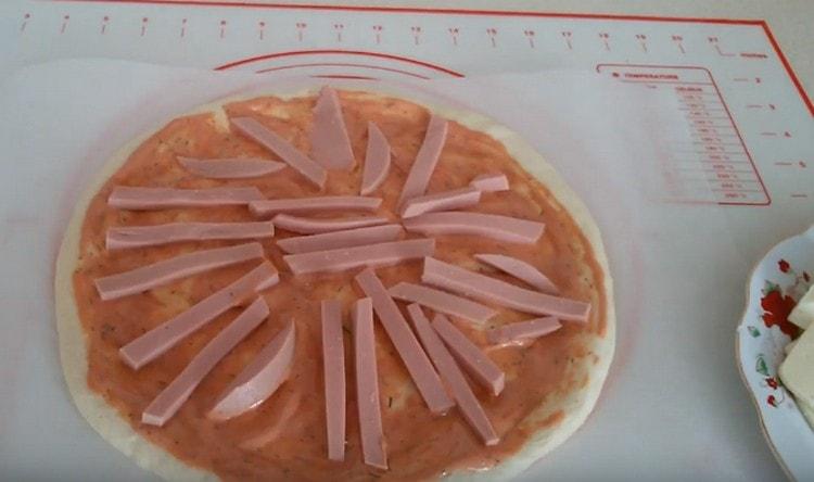 Sosun üstüne sosis parçalarını yerleştirin.