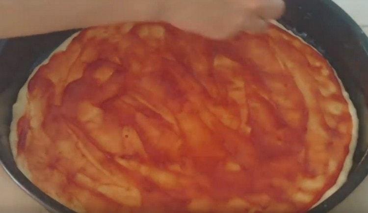 Ungeți baza pentru pizza cu ketchup.