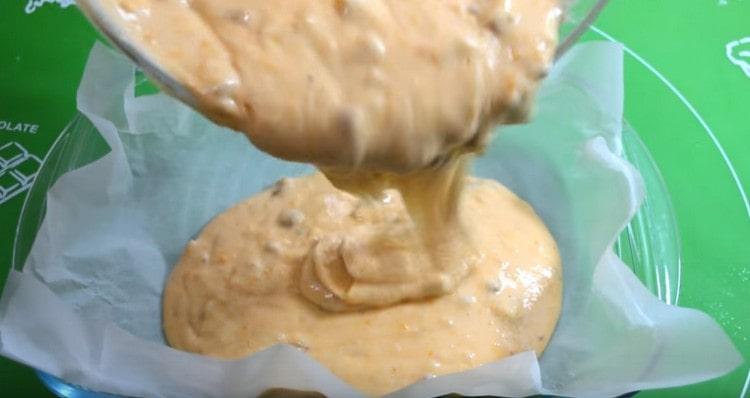 După ce adăugați nuci tocate în aluat, turnați-l într-o formă acoperită cu pergament.