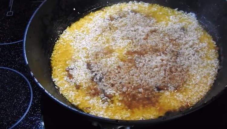 mettez le riz dans une casserole uniformément sur la viande.