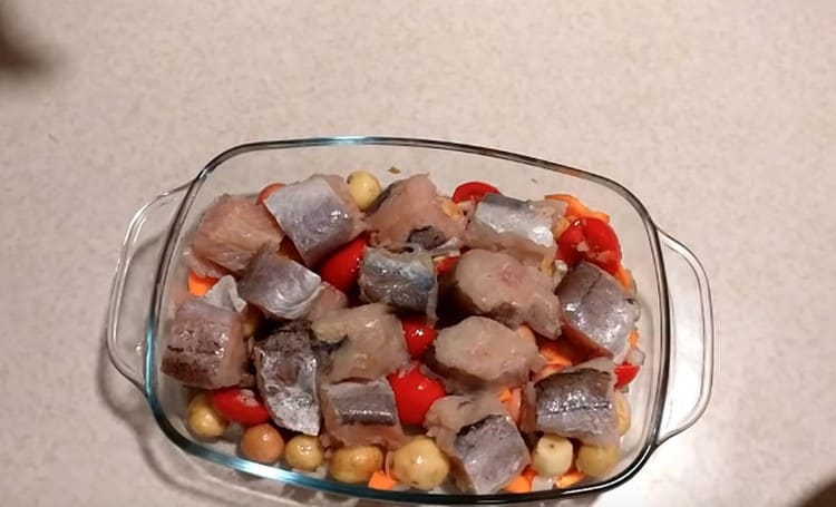 Deasupra legumelor se așază bucăți de pește.