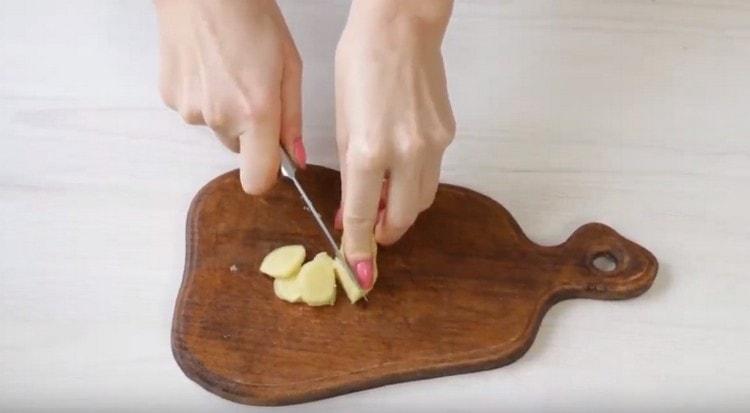 Nous nettoyons et coupons le gingembre avec une racine de gingembre fine.