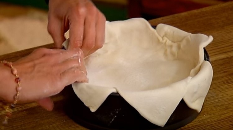 Melancarkan satu lagi helai doh dan tutupnya dengan bahan kerja.