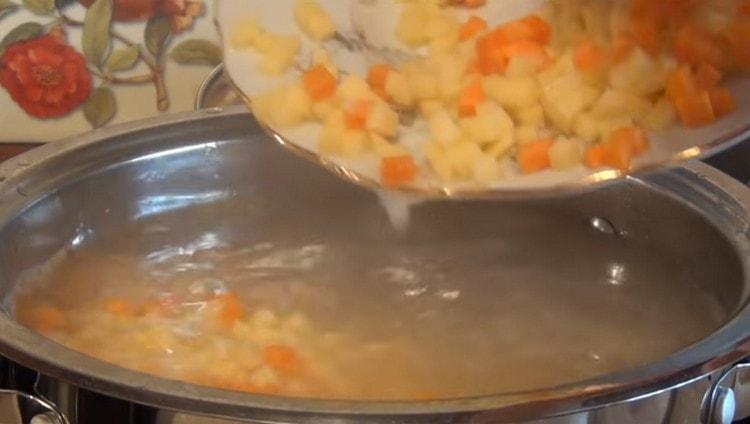 Wir legen Kartoffeln und Karotten in die Fischbrühe.