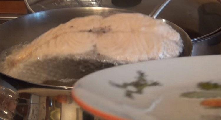 Wir holen den fertigen Fisch aus der Brühe.