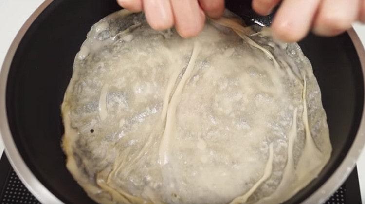 Întindem aluatul într-o tigaie încălzită.