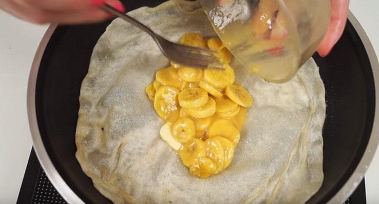 Puneți umplutura pe centrul clătitei în tigaie.