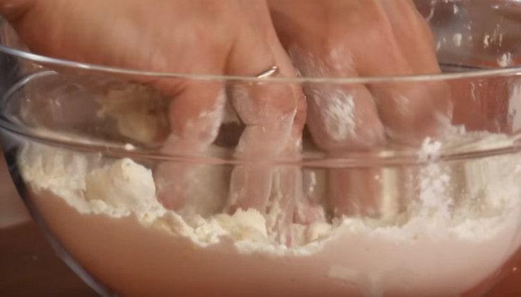 mâinile combină făina cu untul.
