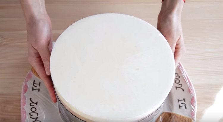 Изваждаме тортата, която е в хладилника от формата, изваждаме филма.