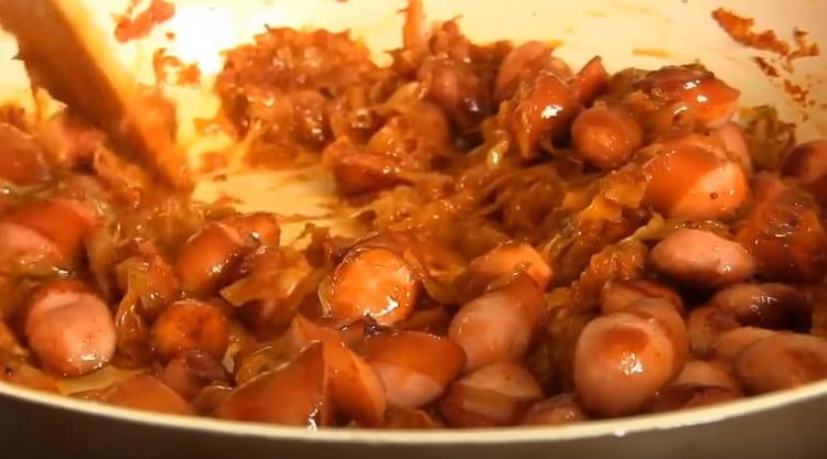 Adicione as salsichas fritas ao repolho, cozinhe por mais alguns minutos.