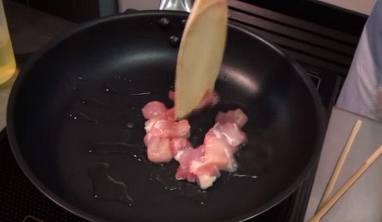 Wir verteilen das Huhn in einer Pfanne und braten es halbfertig an.