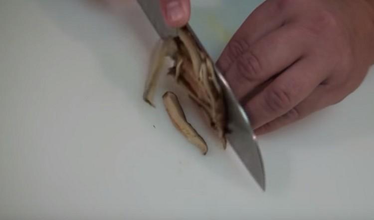 Wir schneiden auch Shiitake-Pilze mit Streifen.