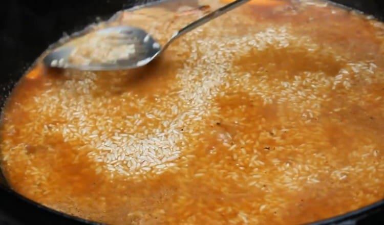 Разстиламе ориза с равен слой, водата трябва напълно да го покрие.