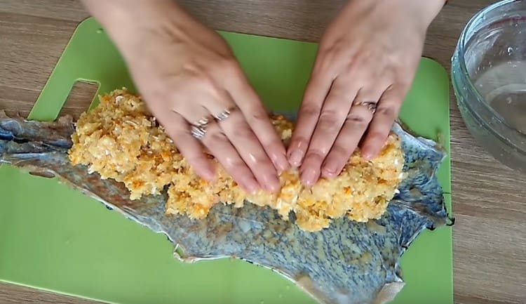 Разстиламе кората на щука върху дъската и разпределяме каймата върху нея.