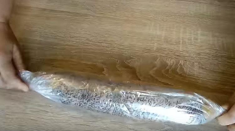 Поставяме пълнената щука в кулинарния ръкав за печене, увиваме, закрепваме краищата.