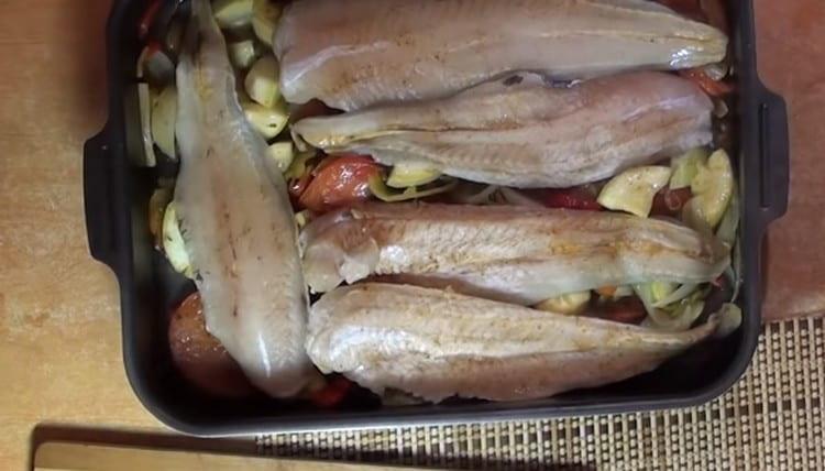 Después de 10 minutos, ponga el pescado sobre las verduras y póngalo en el horno.
